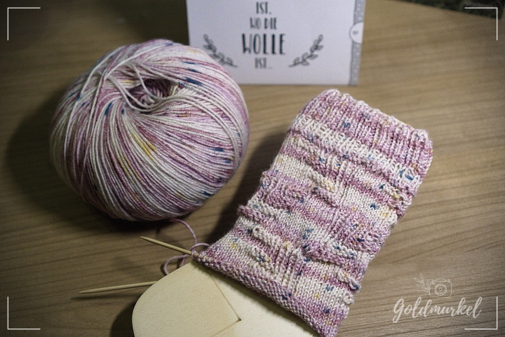 Wollknäuel und angestrickter Socken